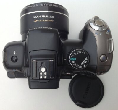 Analoge Kamera auf Holztisch mit Reisetagebuch